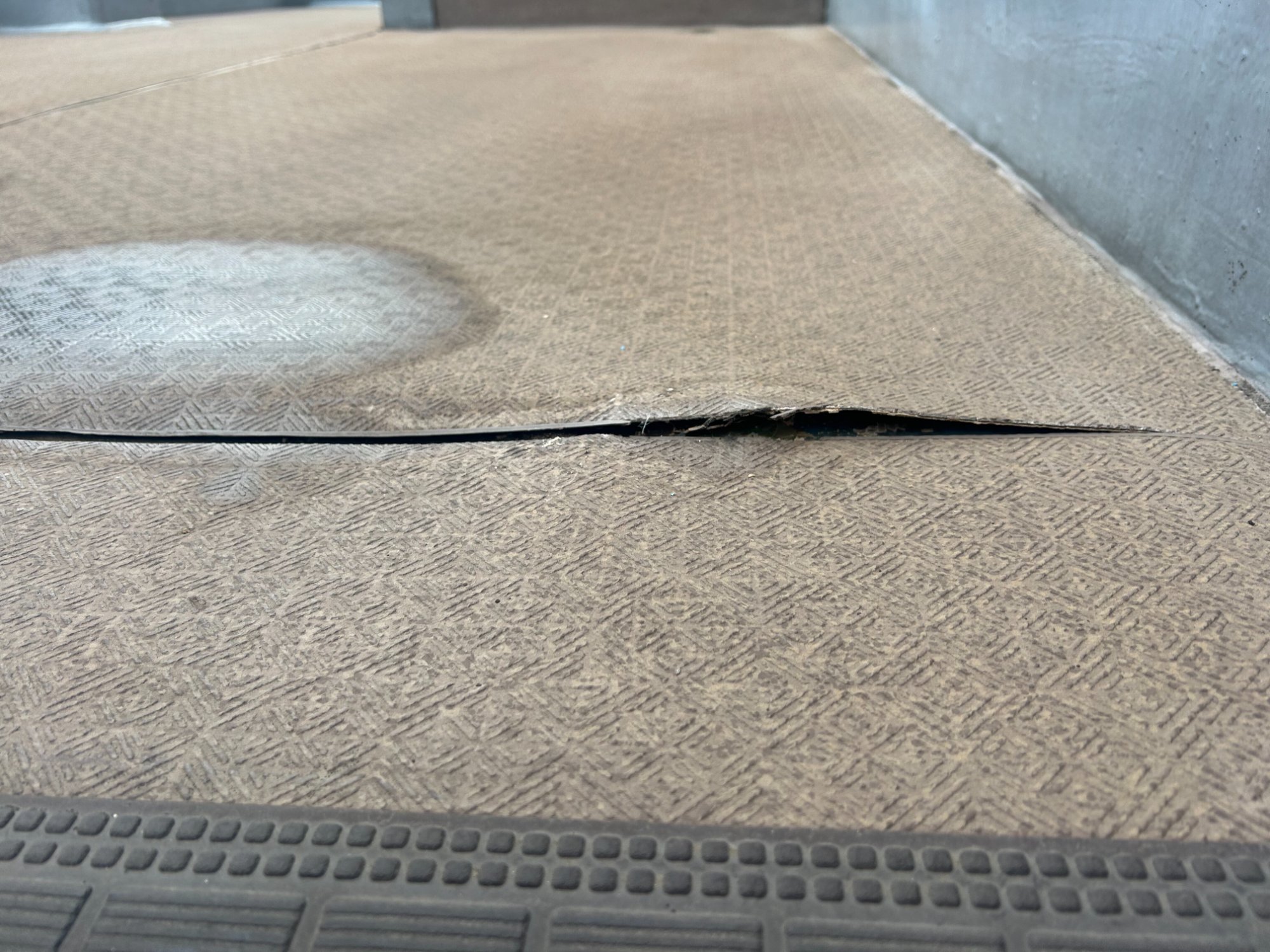 長尺シートの継ぎ目が剥がれて水染みが発生している様子