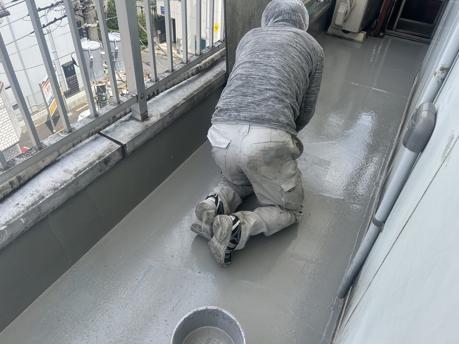 廊下へのウレタン防水材塗布作業中