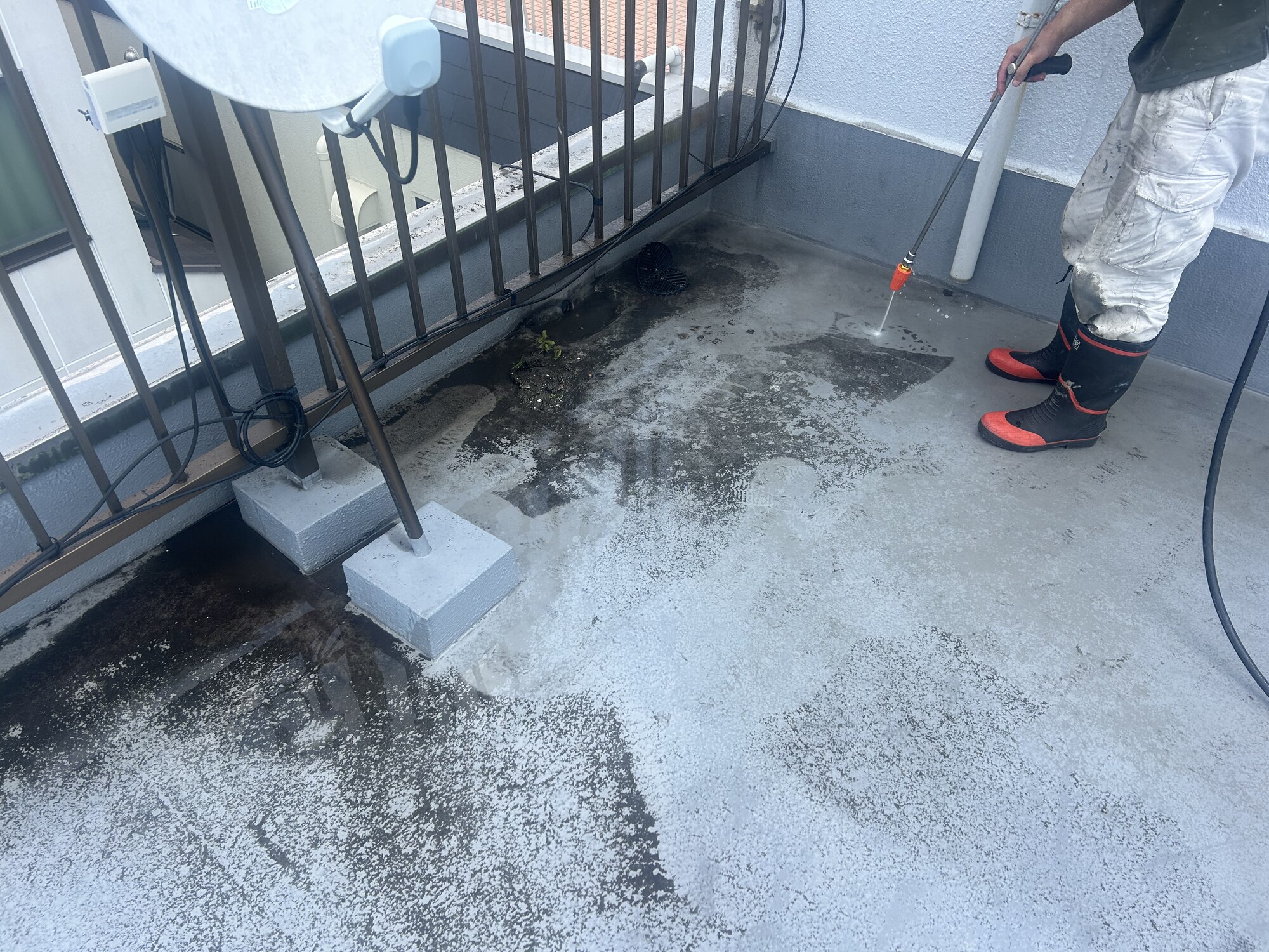 高圧洗浄機で屋上の床面を洗浄している様子
