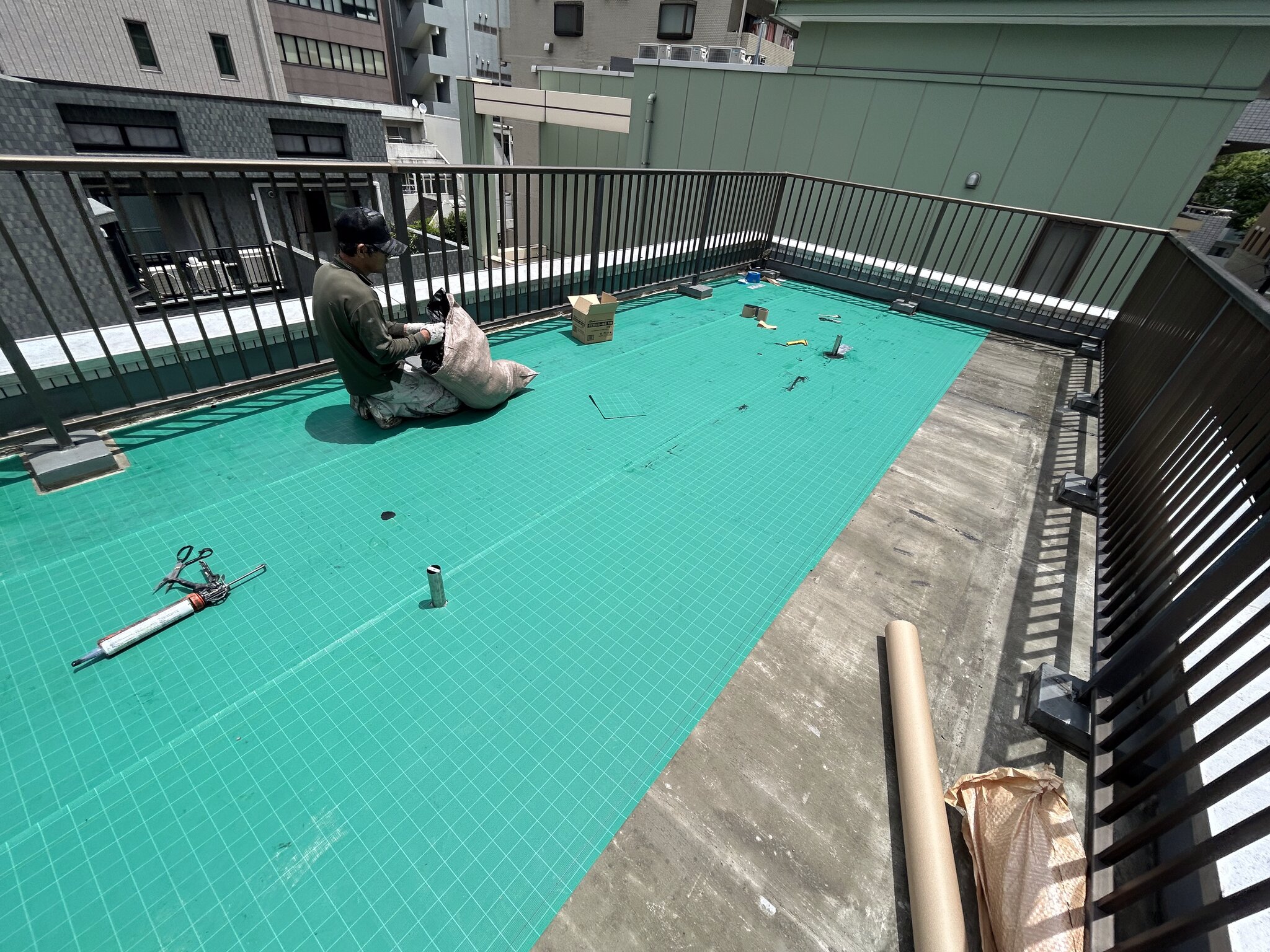 屋上に通気緩衝シートを敷き込む作業