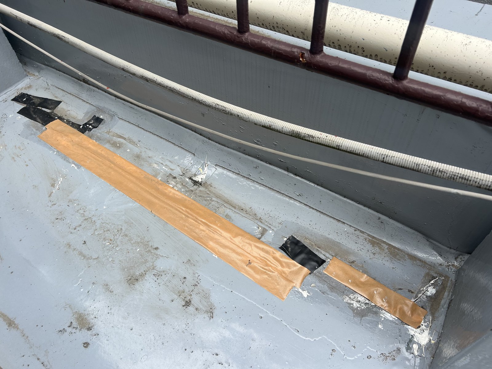 施工前の屋上 立上り際の防水層をテープで応急処置している