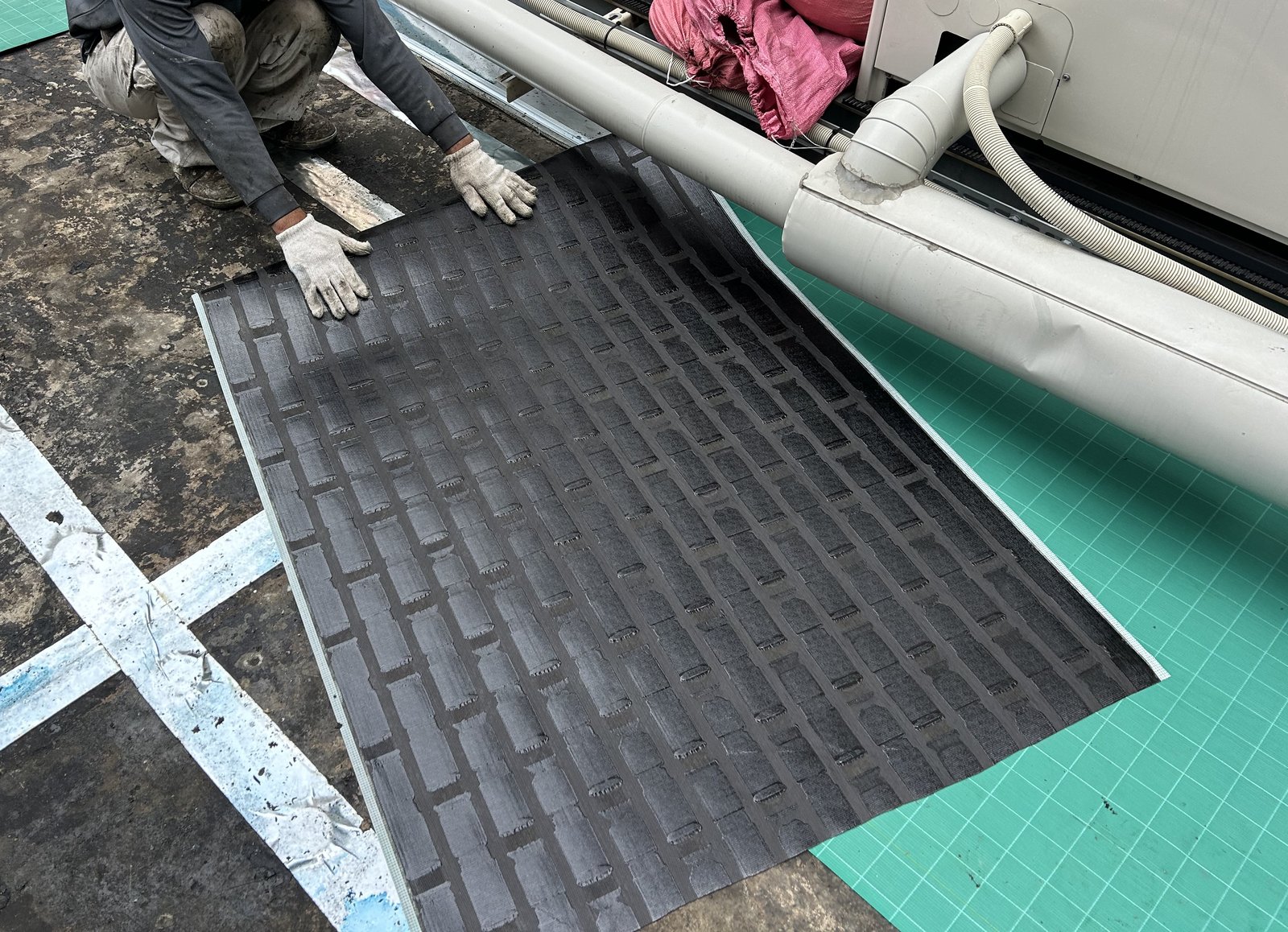 屋上に通気緩衝工法のQVシートを貼る作業