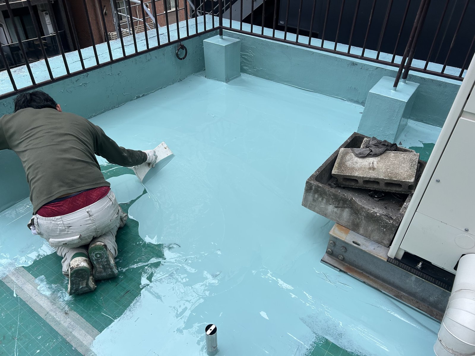 屋上にウレタン防水材の1層目を塗り始めたところ