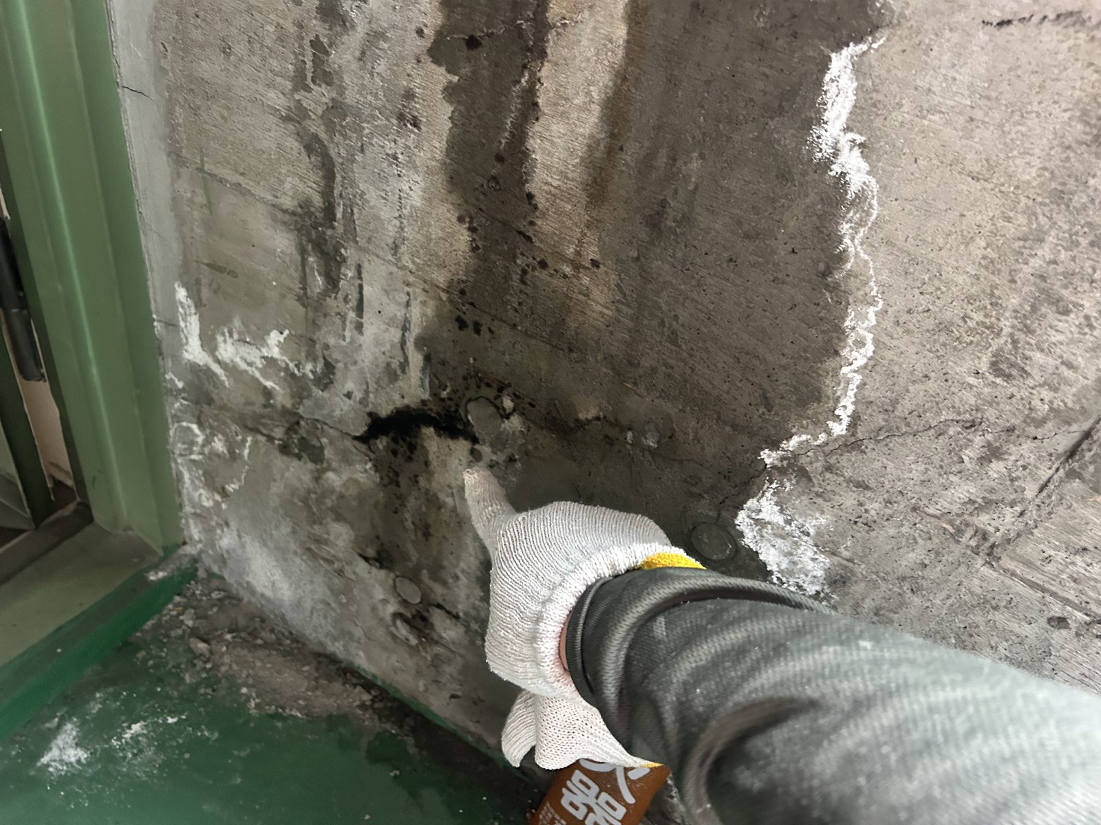 エレベーター室の漏水箇所を指で示している