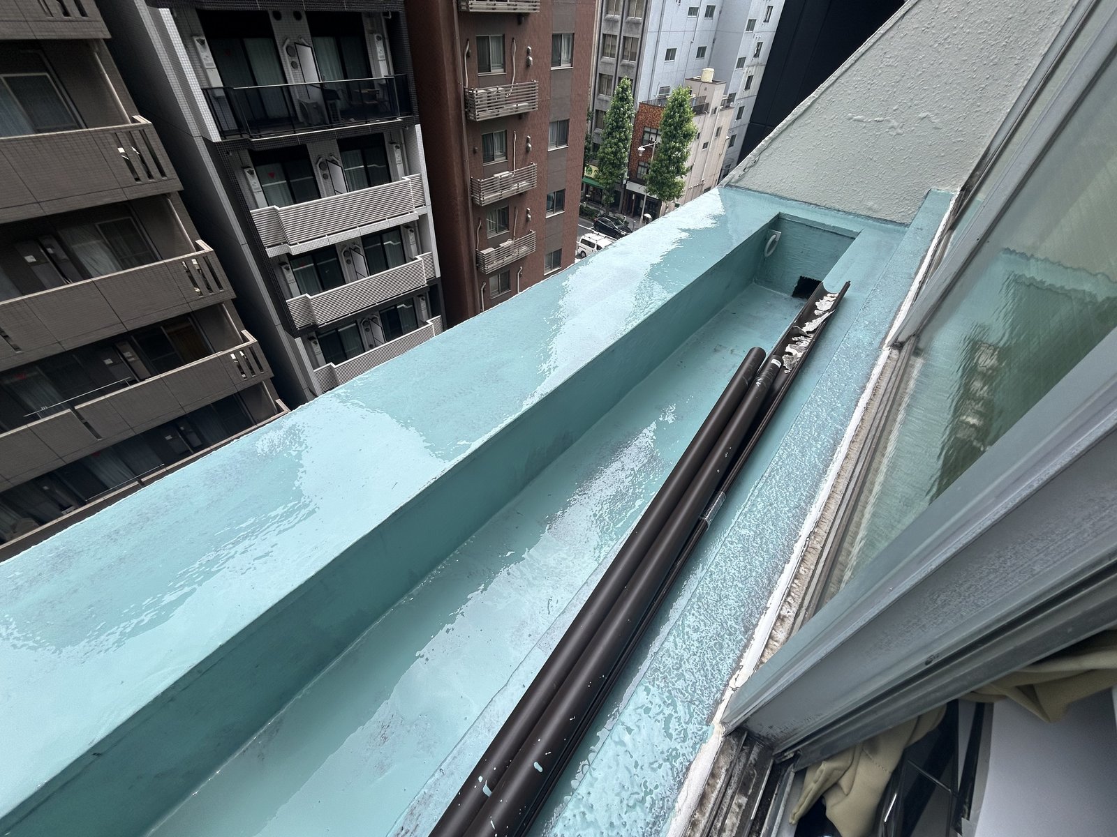窓の外の細長いベランダにウレタン1層目を塗った状態